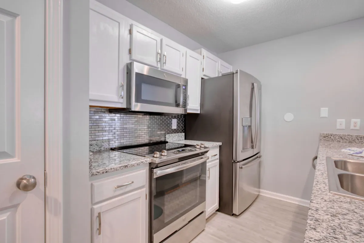 A stylish, functional kitchen featuring stainless steel appliances, granite countertops, and decorative backsplash tiles. The layout encourages both cooking and socializing, with plenty of space for preparing meals and hosting dinner parties.